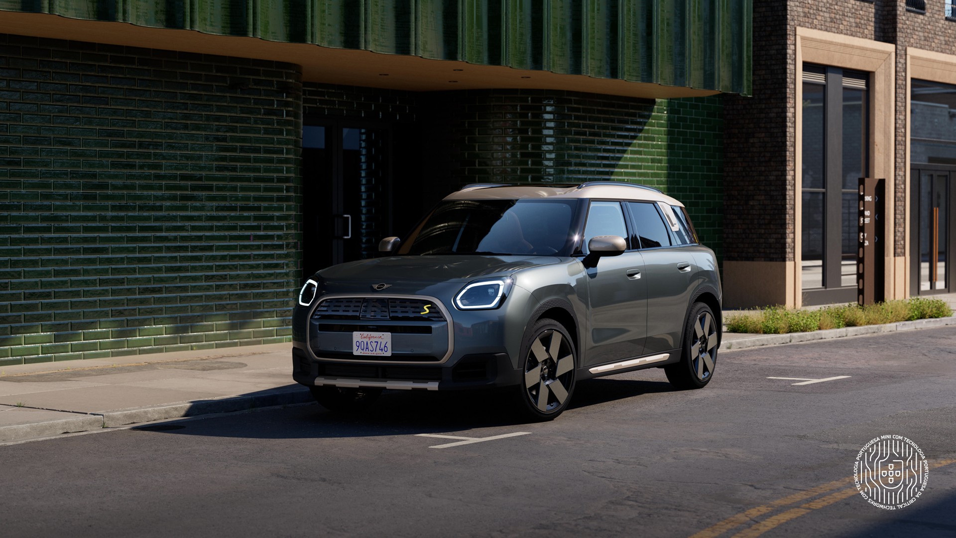 MINI Countryman visto de frente e de lado, estacionado numa rua junto a um edifício  verde